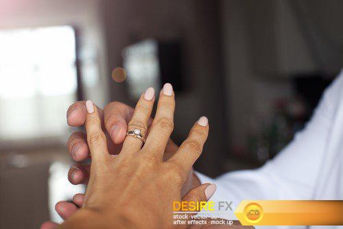 Man holding his girlfriend\'s hand with engagement ring at the restaurant 9X JPEG