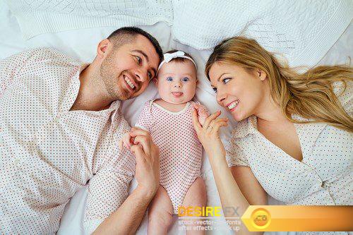 Happy family Parents with baby on the bed Closeup 10X JPEG