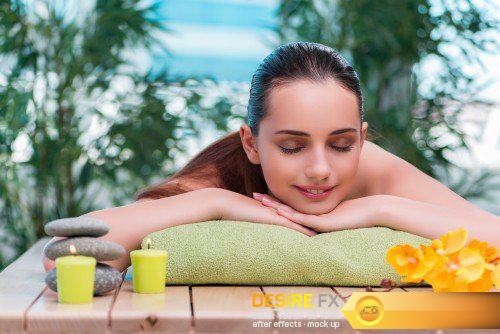 Beautiful young woman laying at spa salon