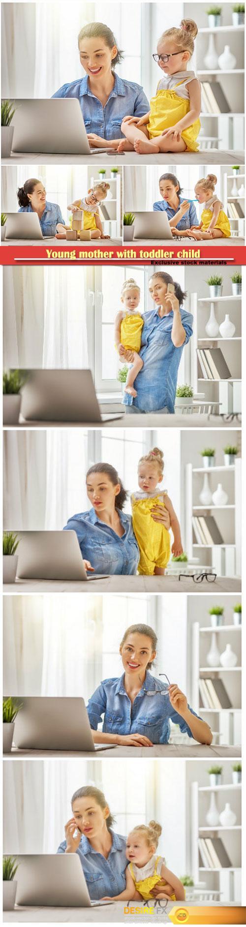Young mother with toddler child working on the computer from home